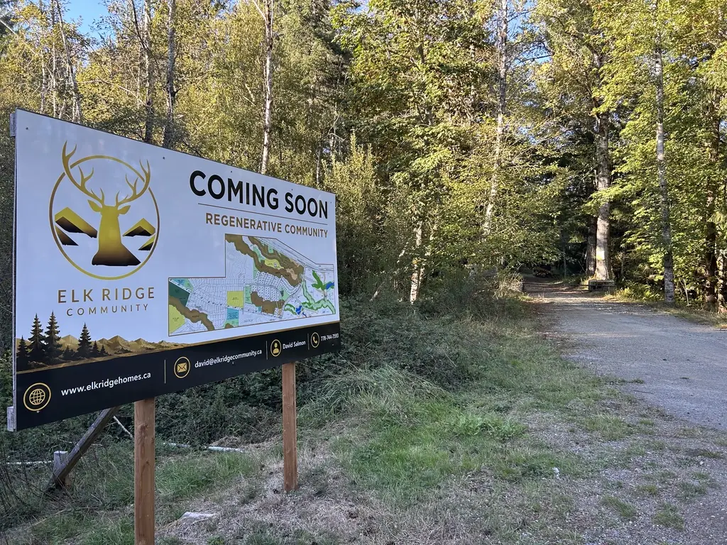 لافتة مجتمع Elk Ridge الجديدة «Coming Soon» بجوار طريق المدخل الحصوي المؤدي إلى الغابة
